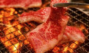 プレミアムカルビで焼肉を網の上で焼いている場面