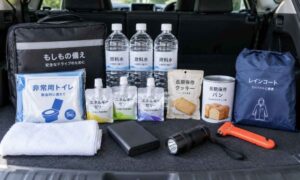 豪雨や道路冠水による帰宅困難に備え、車内に常備する携帯トイレ・飲料水・非常食・モバイルバッテリー・懐中電灯・レインコート・緊急脱出用ハンマー